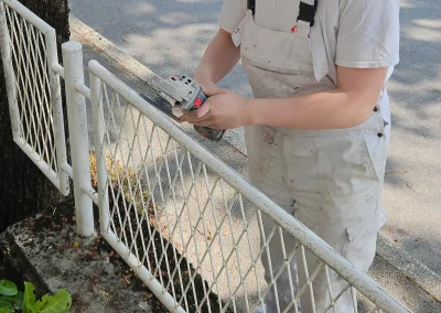 Majstor brusi metalnu ogradu prije lakiranja – Rijeka