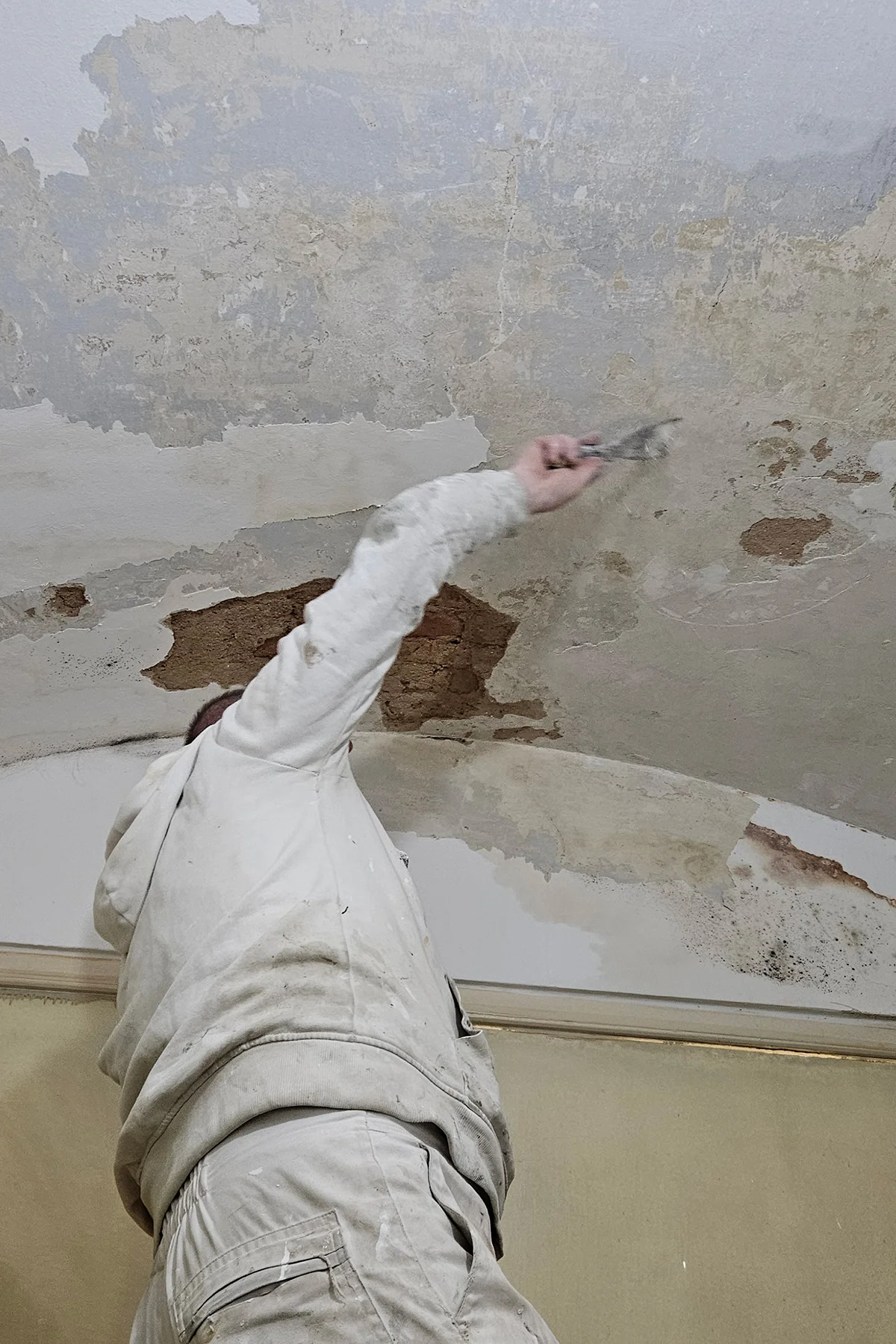 Majstor uklanja oštećene dijelove stropa prije gletanja